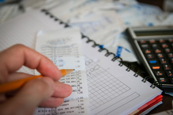 Person Looks at Receipts While Planning Tax Strategies
