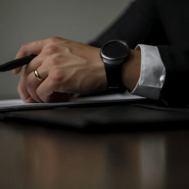 Businessman's Hands Rest on Stack of Papers